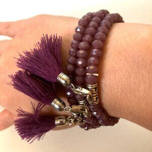 set of three purple beaded bracelets with tassel detailing